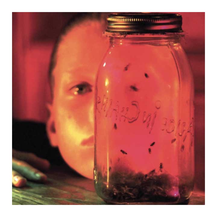 Person looking at a jar with bugs, illuminated by a red light
