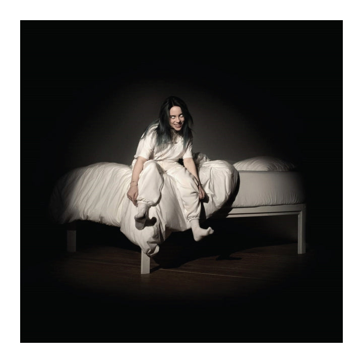 girl sitting on bed, black room