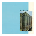 Album cover for 'KARATE' by some boats, featuring a large light blue background, a cream vertical band on the right, and a central square photograph of a city building.