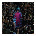 man in pink clothe surrounded by people in drab clothing