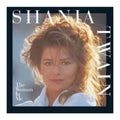Album cover for Shania Twain's 'The Woman In Me', featuring a portrait of the artist with voluminous light-brown hair, wearing a white collared shirt. The text 'SHANIA TWAIN' is displayed prominently in white, and the album title is in the lower-left corner.