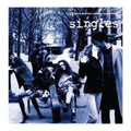 Single album cover for the motion picture soundtrack, featuring a blue-toned photograph of people sitting and standing on a city street, with the title 'singles' in white text at the top.