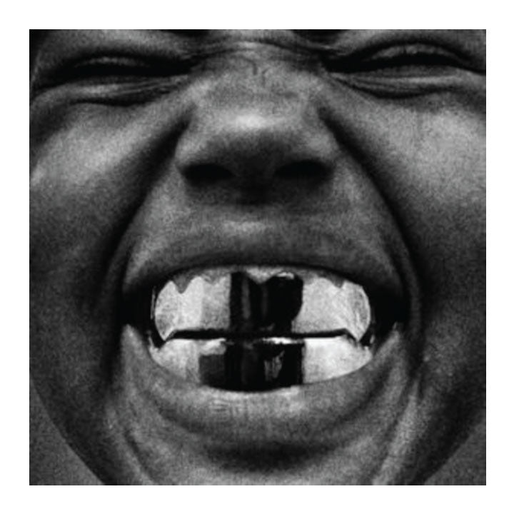 Close-up of a person's mouth with a black object in it, in black and white.